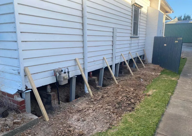 Weatherboard home braced with timber props during restumping – underpinning and reblocking in Torquay